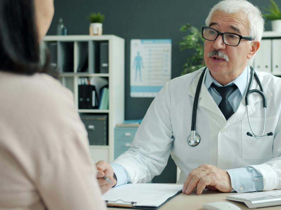 Un médecin explique un diagnostic à sa patiente dans son cabinet